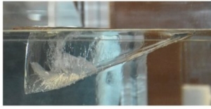 Fig.2 . Vue latérale du bloc de glace(L = 163 mm, Lh = 124 , H = 65mm, Θ =19,5°, température du bain Tb = 22°C). M. Berhanu et al. Physical Review Fluids 11, March 2026, avec autorisation.